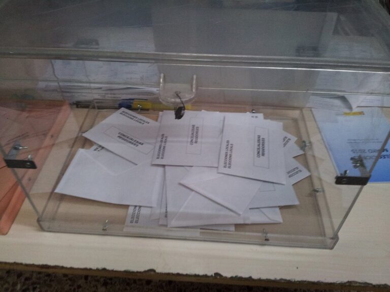 Urna transparente con sobres de votación dentro