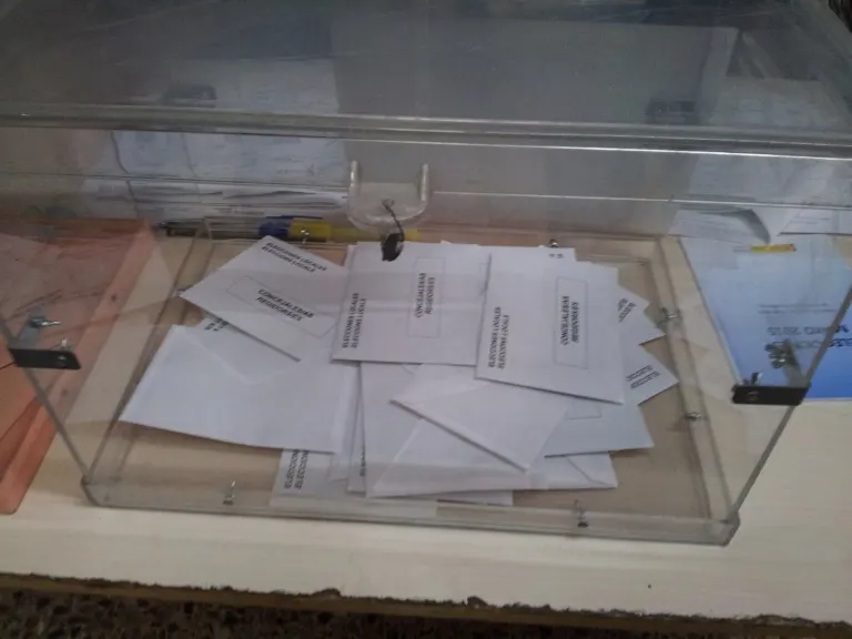 Urna transparente con sobres de votación dentro