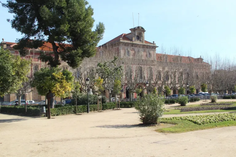 Edificio del Parlamento de Cataluña visto desde el parque de la Ciutadella, con árboles y jardines delante