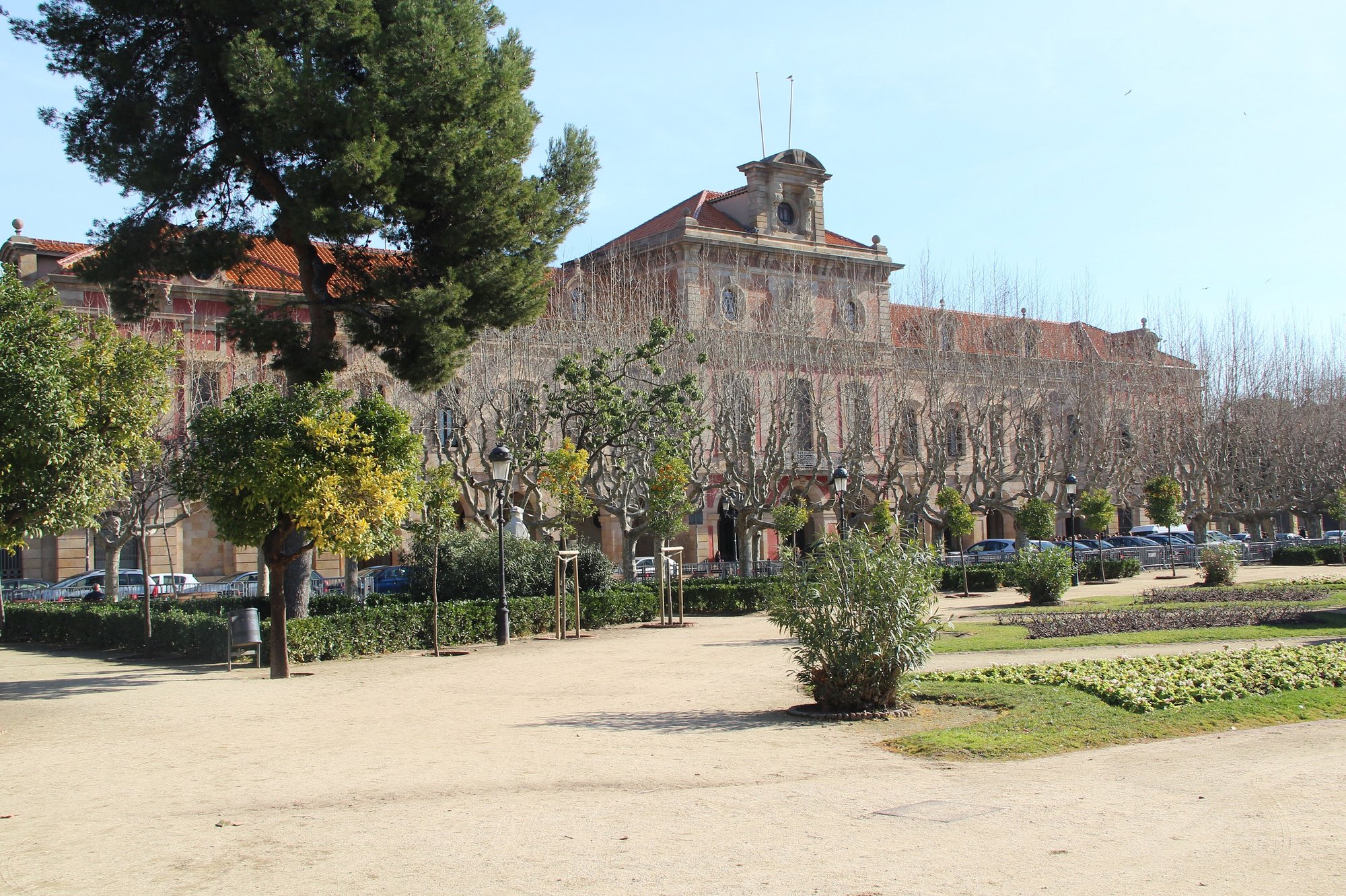 Edificio del Parlamento de Cataluña visto desde el parque de la Ciutadella, con árboles y jardines delante